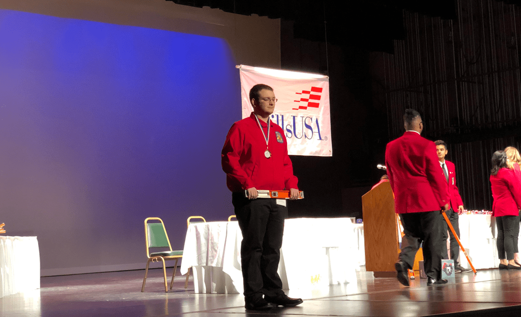 Student on stage with award