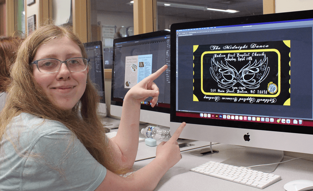 aubree showing her prom ticket design on the computer screen