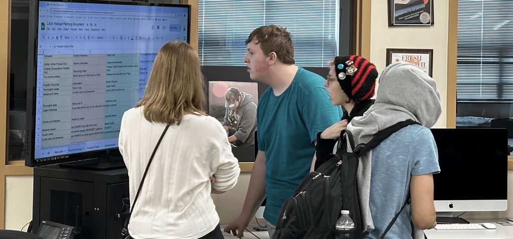 students working on schedule in front of monitor
